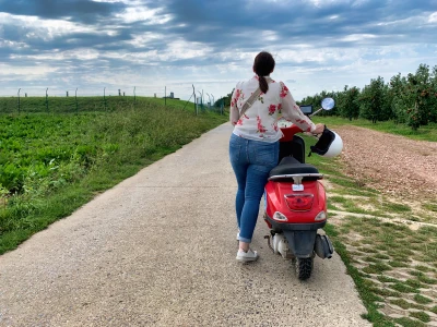 Une personne qui pousse un cyclomoteur.