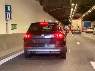 Panneaux indiquant un téléphone de secours, un extincteur et la sortie de secours dans un tunnel.